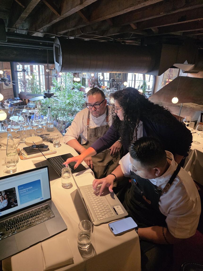 A ChefMod member services lead working through purchasing data with two chefs in their restaurant